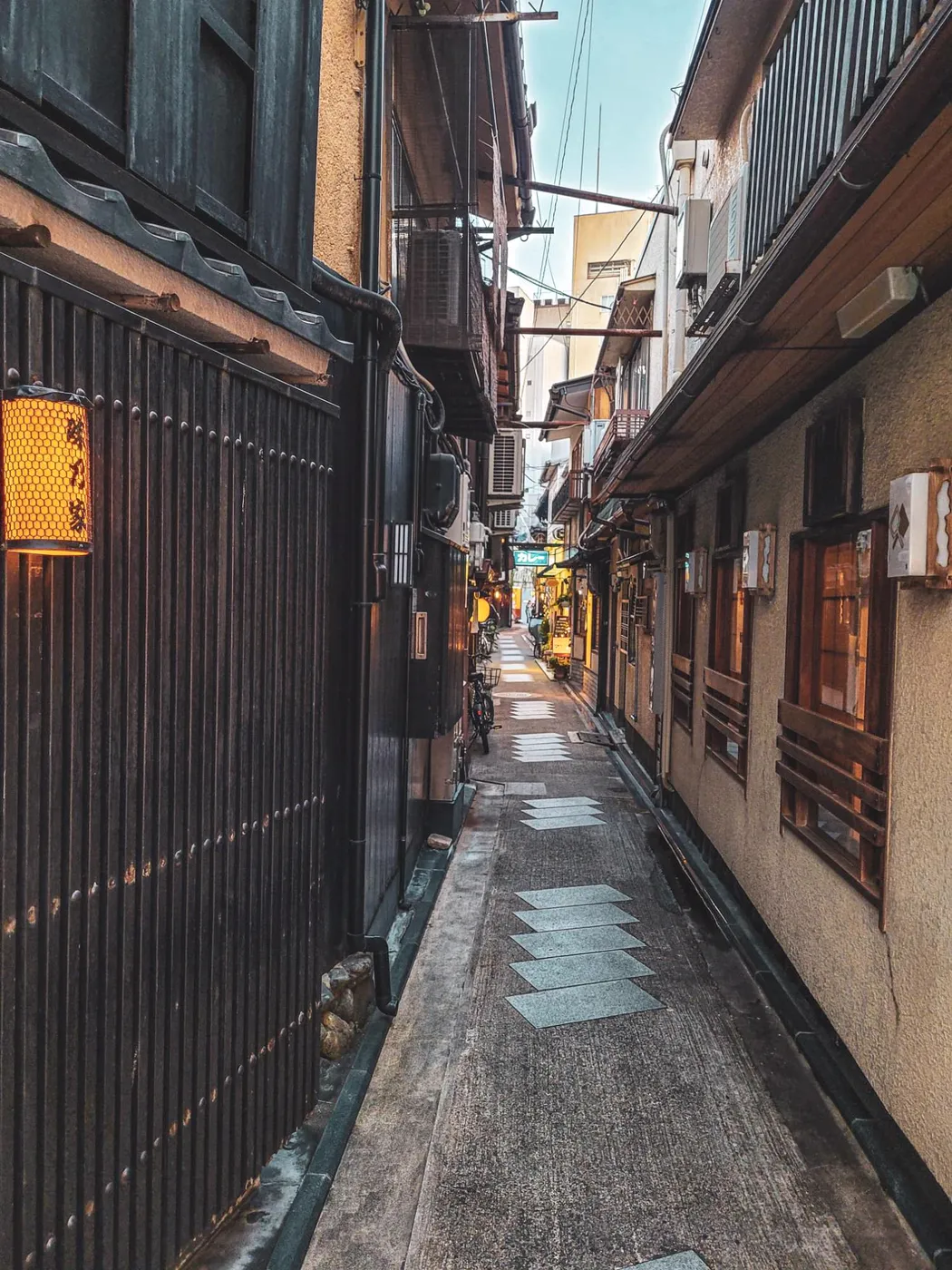 Ruelle étroite et pavée bordée de maisons en bois, à Kyoto